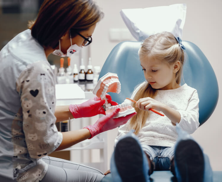 Dentist is looking girl's teeth